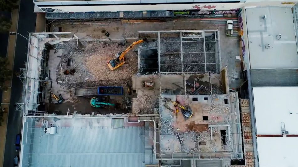 Full quality Birds eye view of excavators and heavy machinery working at the Fremantle high rise demolition site performed by Focus Demolition.