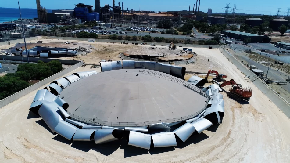 A Kwinana Tank after industrial demolition has taken place showing the peeled back tank material with excavators on the side