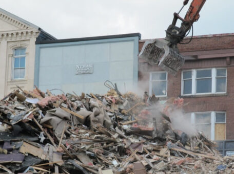 A large equipment arm hanging over scraps of a destroyed building from a Perth demolition project performed by Focus Demolition