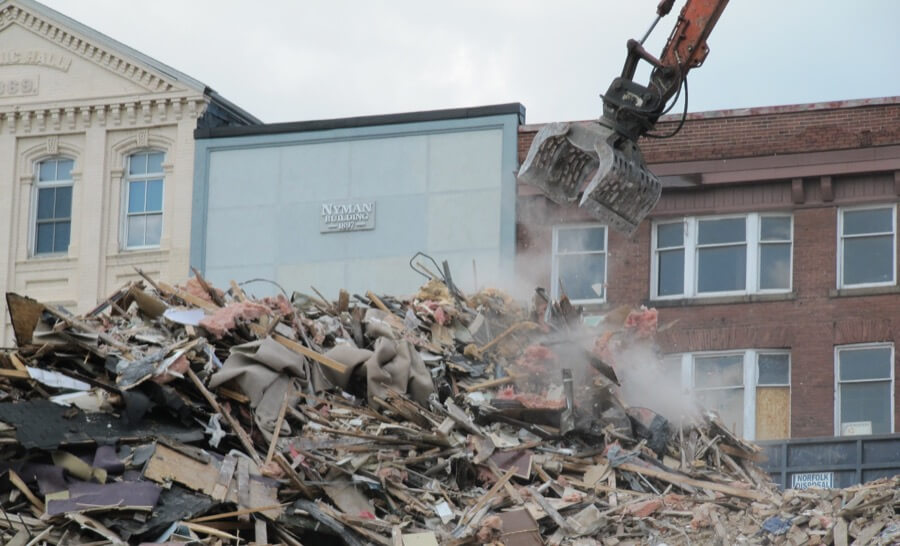 A large equipment arm hanging over scraps of a destroyed building from a Perth demolition project performed by Focus Demolition