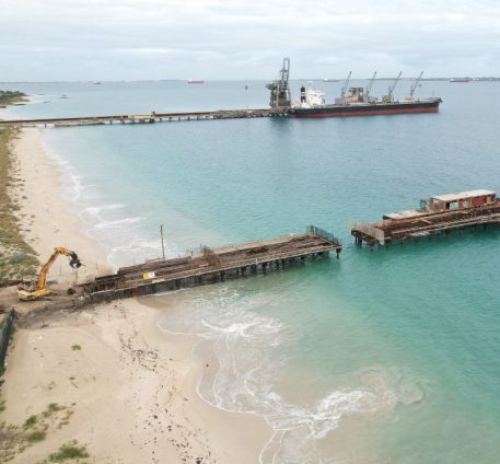 Far wide shot of the Kwinana Jetty Demolition showing the length of the jetty and heavy machinery ready for demolition.