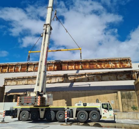 Demolition at the the Fremantle Port RC07 showing a crane lifting a long, rusty metal structure with bright blue skies.