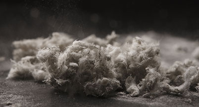 Up close image of friable asbestos showing individual strands of asbestos in a greyscale image.