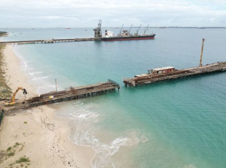 Far wide shot of the Kwinana Jetty Demolition showing the length of the jetty and heavy machinery ready for demolition.