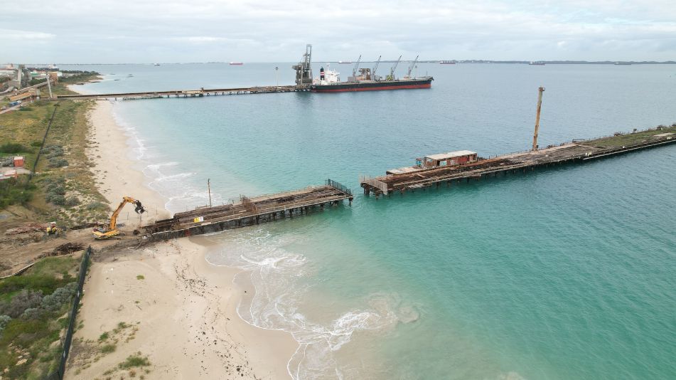 Far wide shot of the Kwinana Jetty Demolition showing the length of the jetty and heavy machinery ready for demolition.