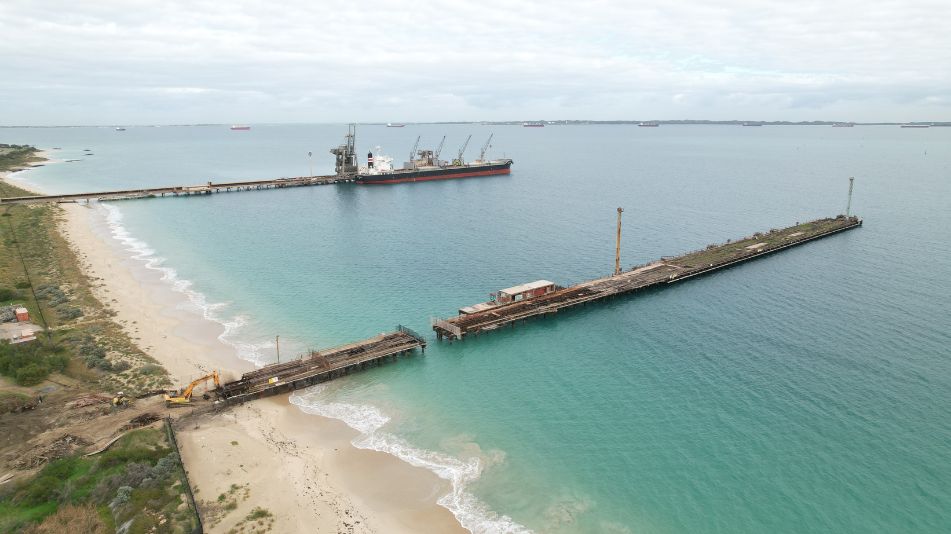 Far wide shot of the Kwinana Jetty Demolition showing the full length of the jetty and heavy machinery ready for demolition.