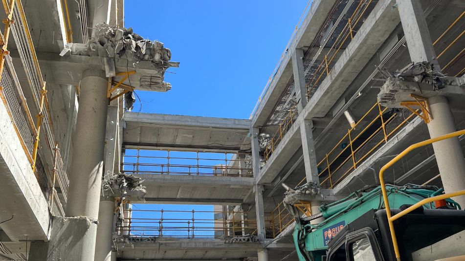 Upward photo of the Midland Square demolition showing torn apart concrete floors with yellow railing and concrete rubble.