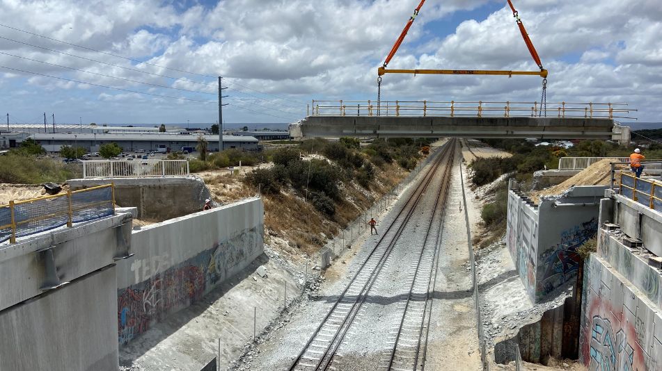 Far wide shot showing the tracks under the Ranford Road Bridge Demolition and the removal of the bridge by crane.