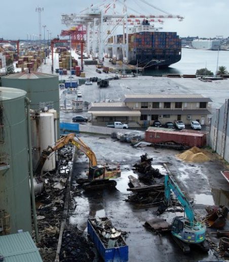 Wide shot of an excavator at work at the Sami Bitumen Plant in North Fremantle demolishing an aging tank as part of Focus Demolition.